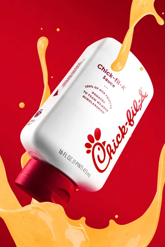 Chick-fil-A sauce bottle studio product shot on a bright yellow background with hard shadow