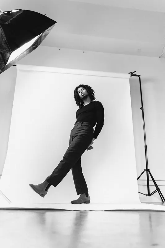 Moody low-key portrait of a musician lit by a single warm source in a dark room