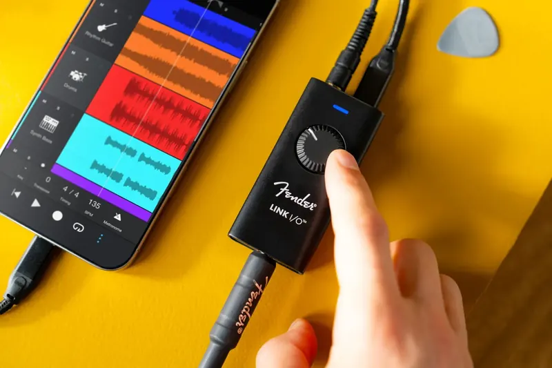 Musician recording into the Fender Studio app in a colourful, plant-filled living room