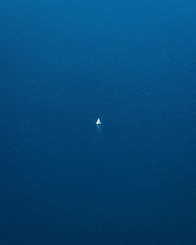 Aerial photograph of a sailboat on the deep blue water of Lake Tahoe