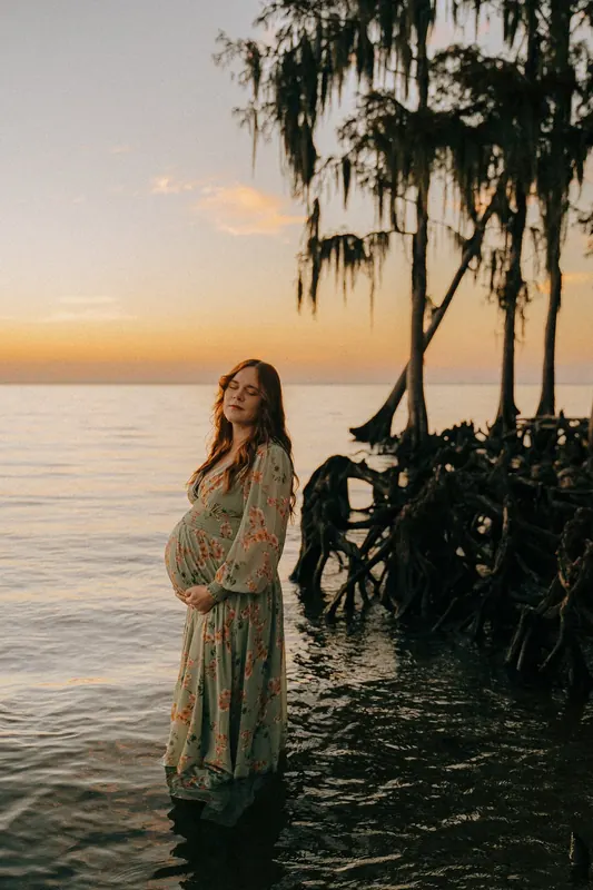 Maternity portrait photographed in a Louisiana swamp at golden hour