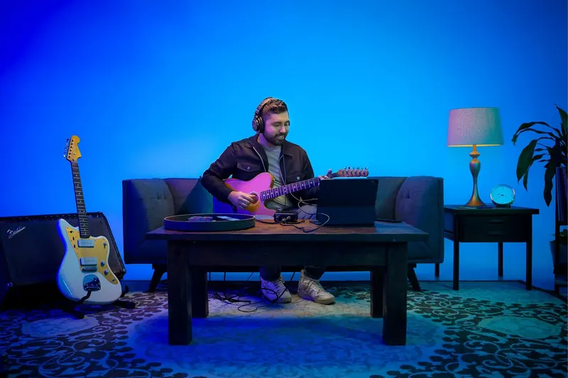 PreSonus AudioBox GO in use on a desk beside a laptop and guitar